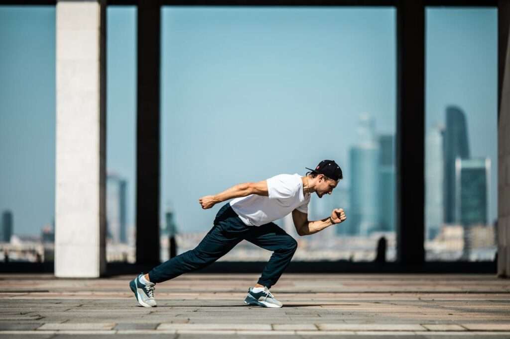 Dynamic shot of a young man sprinting outdoors in an urban setting with skyscrapers in the background.